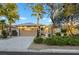 Single-story home with tan exterior and a two-car garage at 4660 Fiore Bella Blvd, Las Vegas, NV 89135