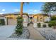 Tan colored home with a landscaped front yard and walkway to the entry at 4660 Fiore Bella Blvd, Las Vegas, NV 89135