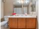 Neat bathroom, featuring a vanity with wood cabinets and a mirror at 9017 Exultation Ct, Las Vegas, NV 89149