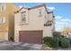 Tan two story house with a brown garage door at 9017 Exultation Ct, Las Vegas, NV 89149