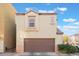 Tan two story house with a brown garage door at 9017 Exultation Ct, Las Vegas, NV 89149