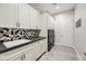 Clean laundry room with white cabinets, hexagon tile, and modern appliances at 4160 W Ford Ave, Las Vegas, NV 89139