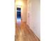 Hallway with wood floors, white walls and cabinetry, and access to the garage at 9728 Echo Hills Dr, Las Vegas, NV 89134