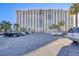 Spacious parking area near a modern high-rise building, complemented by palm trees at 3930 University Center Dr # 1003, Las Vegas, NV 89119