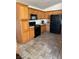 Bright kitchen featuring wood cabinets, black appliances, and tile flooring at 5521 Little Lake Ave, Las Vegas, NV 89122