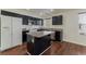 Open kitchen with black cabinets, stainless steel appliances, and a functional island at 6485 Arrow Cottage Ct, Las Vegas, NV 89130