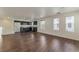 Open-concept living room featuring hardwood floors and a kitchen with dark cabinetry and stainless steel appliances at 6485 Arrow Cottage Ct, Las Vegas, NV 89130