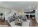 Inviting living room featuring modern gray sofas and a sleek round coffee table, open to the kitchen at 6485 Arrow Cottage Ct, Las Vegas, NV 89130