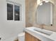 Modern bathroom with white sink, wood vanity, and arched mirror at 211 Granite Ct, Boulder City, NV 89005