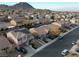 A high-angle shot displays a residential neighborhood with lush landscaping and stunning mountain backdrops at 1053 Plentywood Pl, Henderson, NV 89002