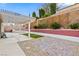 This backyard features a decorative retaining wall, an outdoor kitchen, a covered patio, and low maintenance landscape at 1053 Plentywood Pl, Henderson, NV 89002