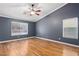 This bedroom features wood floor, ceiling fan, two windows, base molding, and neutral paint at 1053 Plentywood Pl, Henderson, NV 89002
