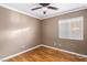 Bright bedroom featuring wood floors, a ceiling fan, and natural light from a window at 1053 Plentywood Pl, Henderson, NV 89002