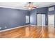 This bedroom features wood floor, ceiling fan, one window, base molding, neutral paint, and a closet at 1053 Plentywood Pl, Henderson, NV 89002