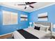Bright blue bedroom with wood floors, fan, queen bed and simple minimalist artwork at 1053 Plentywood Pl, Henderson, NV 89002