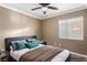 Cozy bedroom with ceiling fan, large window, and a comfortable bed with pillows at 1053 Plentywood Pl, Henderson, NV 89002