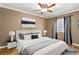 Staged bedroom with bed, side tables, lamps, window with curtains and minimalist artwork at 1053 Plentywood Pl, Henderson, NV 89002