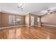 Open-concept living room with hardwood floors, large windows, and neutral wall color at 1053 Plentywood Pl, Henderson, NV 89002