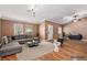 Staged living room featuring a gray sectional sofa, patterned rug, and hardwood floors at 1053 Plentywood Pl, Henderson, NV 89002