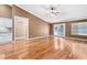 Spacious living room with wood floors, ceiling fan, and natural light from windows and French doors at 1053 Plentywood Pl, Henderson, NV 89002