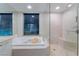 Enjoy a luxurious bath with this soaking tub, glass shower, and city views at 322 Karen Ave # 3707, Las Vegas, NV 89109