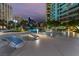 Modern pool deck with lounge chairs, a waterfall feature, and vibrant city views at twilight at 322 Karen Ave # 3707, Las Vegas, NV 89109