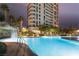 Stunning swimming pool area with waterfall features and views of the high-rise building at night at 322 Karen Ave # 3707, Las Vegas, NV 89109