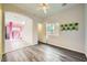 Bright bedroom with wood-look floors and access to balcony at 7745 Tyrell Peaks St, Las Vegas, NV 89139