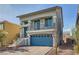 Two-story house with a blue garage door and a balcony at 7745 Tyrell Peaks St, Las Vegas, NV 89139