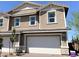 Two-story townhome featuring a white garage door and landscaping at 114 Antler Square Ln, Henderson, NV 89011