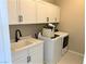 Convenient laundry room with white cabinets, a sink, and washer/dryer at 114 Antler Square Ln, Henderson, NV 89011