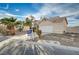 Two-story house with a white garage door and a yard at 1565 Pasture Ln, Las Vegas, NV 89110