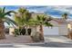 One-story house with a white garage door and desert landscaping at 1565 Pasture Ln, Las Vegas, NV 89110