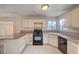 Galley-style kitchen with granite countertops and black appliances at 1565 Pasture Ln, Las Vegas, NV 89110