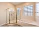 Clean bathroom featuring a glass-doored shower, soaking tub, and tiled floors at 1964 Oliver Springs St, Henderson, NV 89052