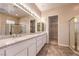 Bright bathroom with a dual-sink vanity, glass-enclosed shower, and a walk-in closet at 1964 Oliver Springs St, Henderson, NV 89052