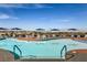 Community pool with lounge chairs, tables, and umbrellas with mountain views at 1964 Oliver Springs St, Henderson, NV 89052