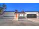 Remodeled home with red door, black garage door, and desert landscaping at 2500 W Oakey Blvd, Las Vegas, NV 89102