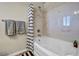 Bathroom with tub shower, striped shower curtain, and marble-like wall accents at 5728 Collier Falls Ave, Las Vegas, NV 89139