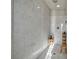 Large walk in shower with marble walls and wooden bench at 5728 Collier Falls Ave, Las Vegas, NV 89139