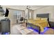 Modern bedroom with a yellow comforter, a home office, and blue accent lighting at 5728 Collier Falls Ave, Las Vegas, NV 89139