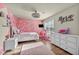 Charming bedroom with pink walls, white dresser, and wood flooring at 5728 Collier Falls Ave, Las Vegas, NV 89139