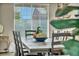 Farmhouse dining table with wooden chairs sits in front of a large window at 5728 Collier Falls Ave, Las Vegas, NV 89139