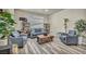 Cozy living room with gray armchairs, wood-like flooring, and a large coffee table at 5728 Collier Falls Ave, Las Vegas, NV 89139