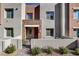 Modern two-story townhome with stone accents and a red door at 600 N Carriage Hill Dr # 1113, Las Vegas, NV 89138