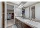 Bathroom with double sinks, dark cabinets, and an open doorway into another room at 6800 Equinox Cliff St, Las Vegas, NV 89135