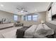 This bedroom features neutral walls, a ceiling fan, and three large windows overlooking a serene view at 6800 Equinox Cliff St, Las Vegas, NV 89135