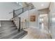 Elegant foyer with staircase, hardwood floors, and view into open-concept kitchen at 6800 Equinox Cliff St, Las Vegas, NV 89135