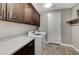 Well-equipped laundry room with a front-load washer and dryer, counter space and cabinets at 6800 Equinox Cliff St, Las Vegas, NV 89135