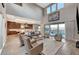 Modern living room with a cozy fireplace, expansive windows, and an open layout connecting to the kitchen at 6800 Equinox Cliff St, Las Vegas, NV 89135